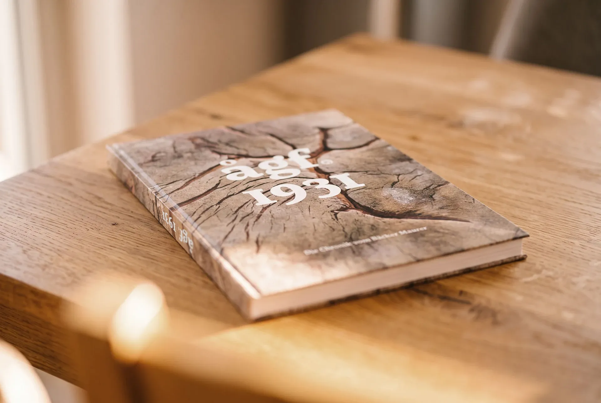 Das Chronikbuch „ågf 1931“ liegt auf einem Holztisch im Sonnenlicht