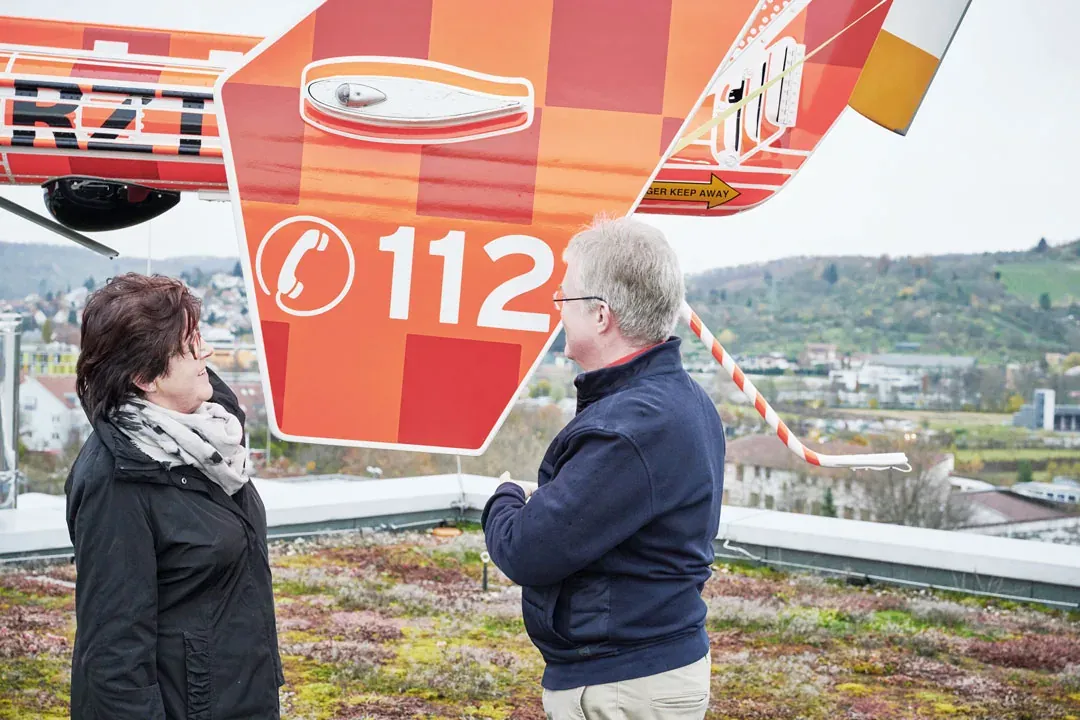 Anna Maurer und Björn Steiger stehen an einem Helikopter
