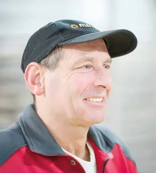 Lothar in roter Arbeitsjacke und Maurer-Kappe