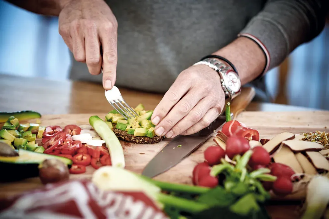 Man verdrückt Avocado auf dem Brot