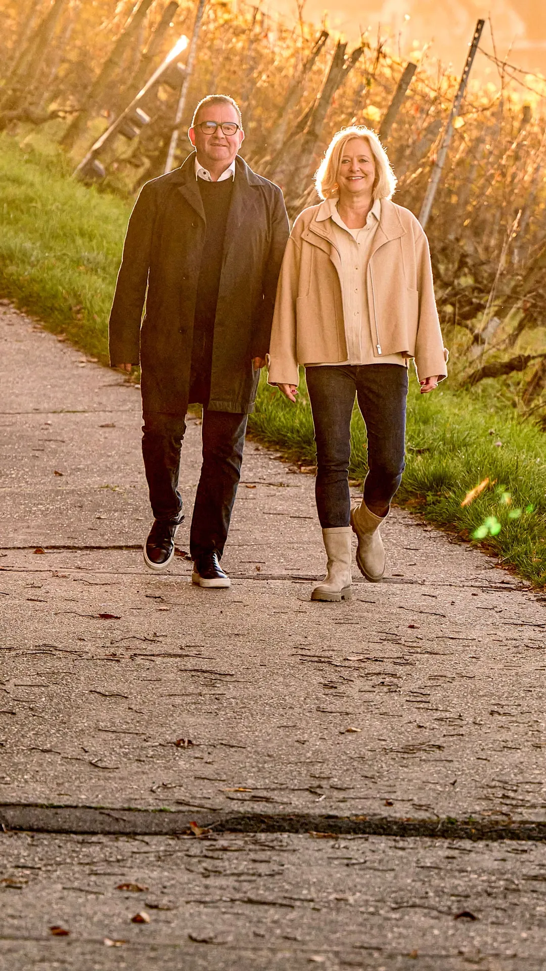 Claudia Maurer und Tobias Maurer gehen im Herbst einen Weg durch die Weinberge